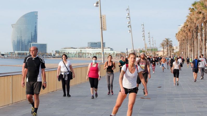 La gente se ejercita a lo largo de una explanada de Barcelona (España), a principios del 2 de mayo de 2020, durante las horas permitidas por el gobierno para ejercitarse, por primera vez desde el comienzo de un cierre nacional para prevenir la propagación de la enfermedad COVID-19. (Pau Barrrena/AFP vía Getty Images)