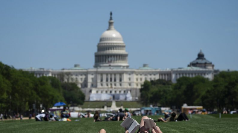 La gente pasa tiempo en el National Mall de Washington el 2 de mayo de 2020. A principios del día, grandes grupos de personas se reunieron al aire libre para ver a los Blue Angels y los Thunderbirds mientras sobrevolaban la zona de D.C. en homenaje al personal sanitario que trabaja contra la propagación de la pandemia del virus PCCh (COVID-19). (Sarah Silbiger/Getty Images)