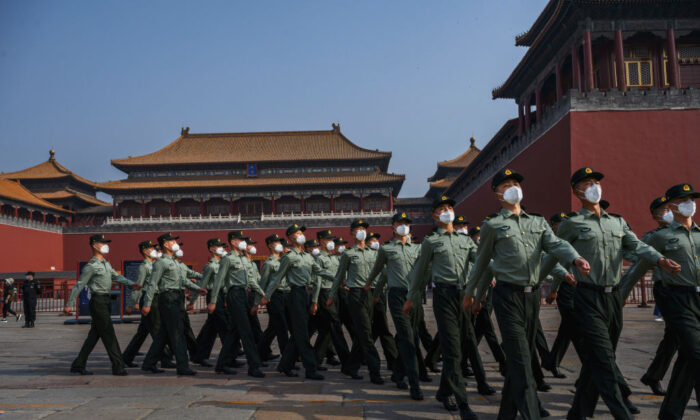 La policía paramilitar china lleva mascarillas de protección mientras marcha por la entrada de la Ciudad Prohibida en Beijing, China, el 2 de mayo de 2020. (Kevin Frayer/Getty Images)