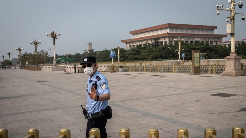 Un agente de policía gesticula mientras asegura un área en los alrededores de la Plaza Tiananmen durante el Día Mundial de la Libertad de Prensa en Beijing, China, el 3 de mayo de 2020. (NICOLAS ASFOURI/AFP a través de Getty Images)