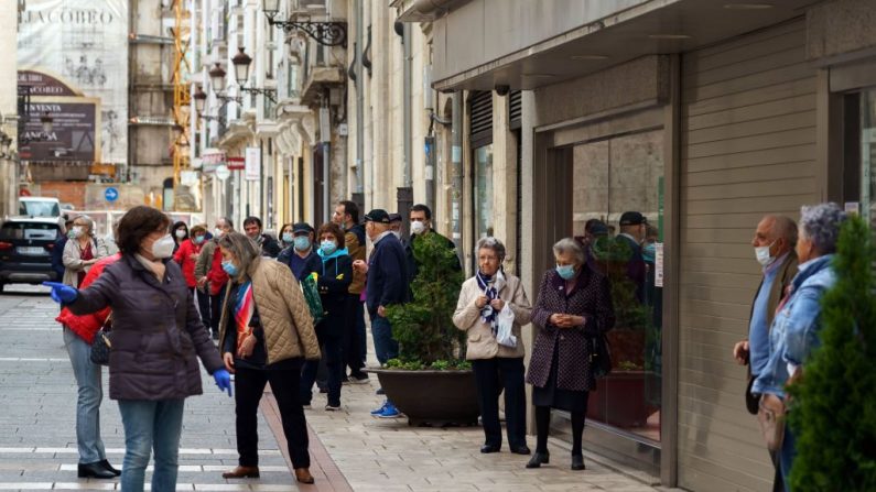La gente hace cola en una calle de Burgos (España) para entrar en una oficina bancaria, el 4 de mayo de 2020, durante un encierro nacional para evitar la propagación de la enfermedad COVID-19. (CESAR MANSO/AFP vía Getty Images)