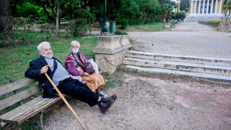 Una pareja de ancianos que no ha estado afuera por casi dos meses disfruta del clima mientras se sientan en un banco en un parque de Atenas el 4 de mayo de 2020. (Foto de LOUISA GOULIAMAKI/AFP a través de Getty Images)
