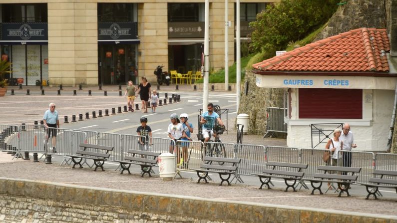 La gente camina y va en bicicleta a lo largo de una barrera mientras la playa de Grande Plage se cierra en Biarritz, al suroeste de Francia, el 4 de mayo de 2020, ya que el país está bloqueado para detener la propagación del COVID-19 causado por el virus del PCCh. (GAIZKA IROZ/AFP vía Getty Images)