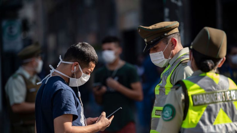 La policía controla a los ciudadanos en la Plaza de Armas de Santiago, Chile, el 06 de mayo de 2020 en medio del confinamiento obligatorio en Santiago, ante el aumento de los casos del virus del PCCh. (MARTIN BERNETTI/AFP vía Getty Images)