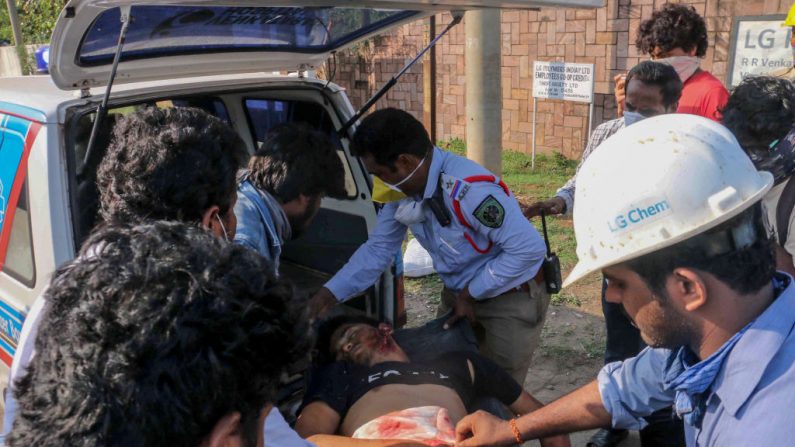 En una fotografía de archivo, el personal de la policía y las personas llevan a un hombre (c) que se desmayó tras un incidente en Visakhapatnam (India) el 7 de mayo de 2020. (STR/AFP vía Getty Images)