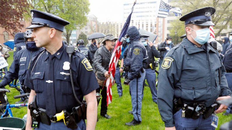 La policía estatal de Michigan patrulla mientras los manifestantes protestan en Lansing, Michigan, el 14 de mayo de 2020. (Jeff Kowalsky/AFP a través de Getty Images)
 
