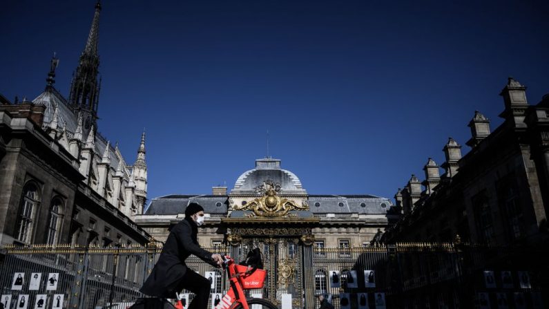 Un hombre pasa en bicicleta frente al histórico Palacio de Justicia situado en la Île de la Cité de París, el 15 de mayo de 2020, durante un levantamiento parcial de las restricciones debido a que la pandemia Covid-19 causada por el nuevo coronavirus. (PHILIPPE LOPEZ/AFP vía Getty Images)