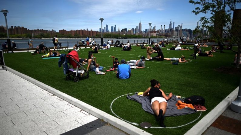 La gente practica el distanciamiento social en círculos blancos en el Parque del Dominó, durante la pandemia de Covid-19 el 17 de mayo de 2020, en el barrio de Brooklyn de la ciudad de Nueva York. (JOHANNES EISELE/AFP vía Getty Images)