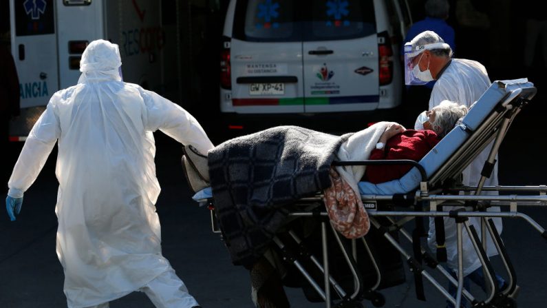 Trabajadores de la salud llevan a un paciente con síntomas de COVID-19 a una sala de emergencias del Hospital San José el 18 de mayo de 2020 en Santiago de Chile (Chile). (Marcelo Hernandez/Getty Images)