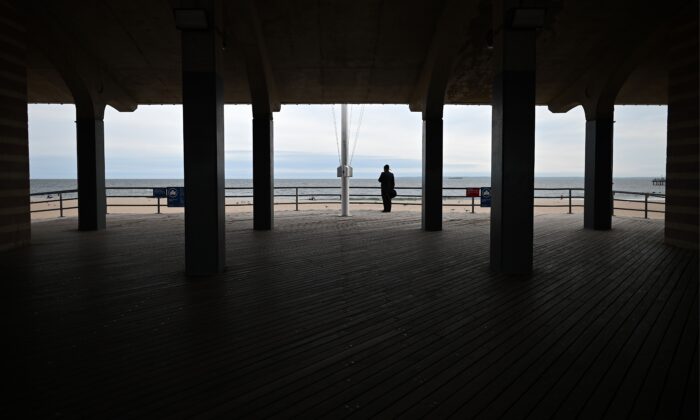 Un hombre con una mascarilla se encuentra en el muelle de Coney Island Beach el 18 de mayo de 2020 en la Ciudad de Nueva York. El alcalde Bill de Blasio dijo que la Ciudad aún no está lista para abrir playas para nadar.  (Foto de JOHANNES EISELE/AFP a través de Getty Images)
