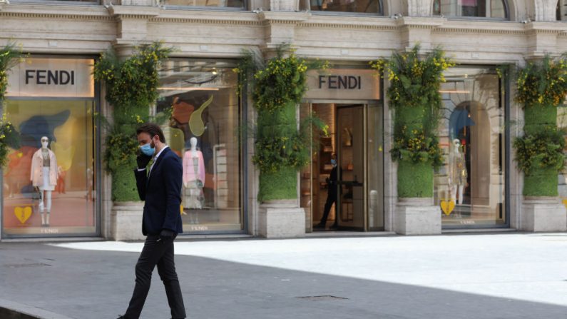 Un hombre con una máscara protectora habla por teléfono frente a la tienda Fendi el 19 de mayo de 2020 en Roma, Italia. (Marco Di Lauro/Getty Images)
