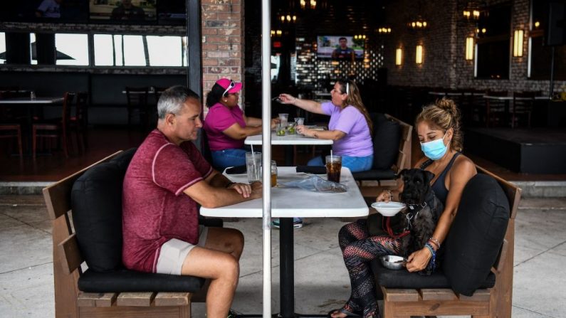 La gente come sentada fuera de un restaurante en Fort Lauderdale Beach Boulevard en Fort Lauderdale, Florida (EE.UU.) el 18 de mayo de 2020. (CHANDAN KHANNA/AFP vía Getty Images)