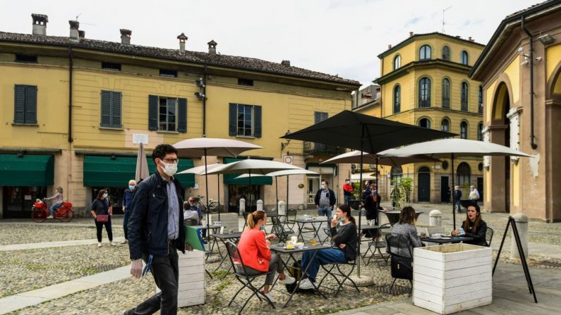 Los residentes toman una copa en la terraza de un café y realizan sus actividades el 20 de mayo de 2020 en el centro de Codogno, al sureste de Milán (Italia), uno de los pueblos en el epicentro de la epidemia de COVID-19 en febrero. (MIGUEL MEDINA/AFP vía Getty Images)