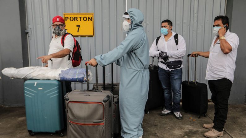 Ciudadanos estadounidenses hacen cola en la entrada del aeropuerto Augusto C. Sandino de Managua (Nicaragua) el 20 de mayo de 2020. (STR/AFP vía Getty Images)