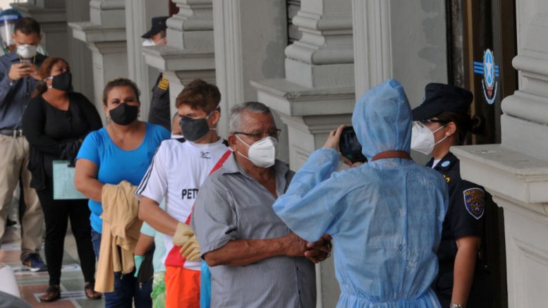 La gente hace cola frente al ayuntamiento de Guayaquil, Ecuador, el 20 de mayo de 2020 en medio de la pandemia del virus del PCCh. (JOSE SANCHEZ LINDAO/AFP vía Getty Images)