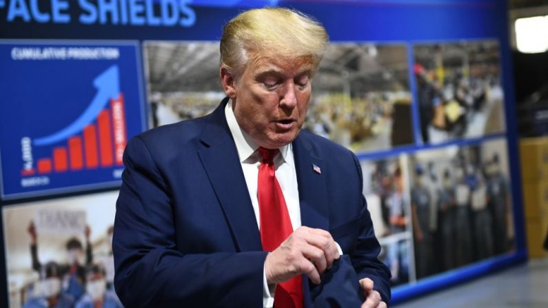 El presidente de Estados Unidos, Donald Trump, sostiene una mascarilla mientras habla durante una visita a la planta de Ford Rawsonville en Ypsilanti, Michigan, el 21 de mayo de 2020. (Foto de BRENDAN SMIALOWSKI/AFP a través de Getty Images)