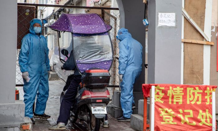 Voluntarios comprueban la identidad de un residente a la entrada de un complejo residencial en la ciudad de Jilin, China, el 22 de mayo de 2020. (STR/AFP vía Getty Images)