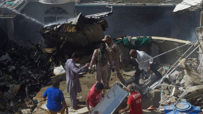 Trabajadores de rescate se reúnen en el sitio después de que un vuelo de Pakistan International Airlines se estrelló en un barrio residencial de Karachi (Pakistán) el 22 de mayo de 2020. (ASIF HASSAN / AFP vía Getty Images)