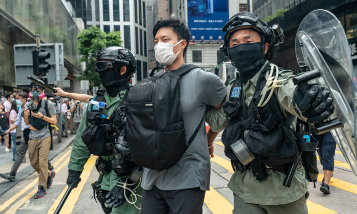 Un honkonés es detenido por la policía antidisturbios durante una reunión de "Almuerzo contigo" en el distrito central de Hong Kong el 27 de mayo de 2020. (Anthony Kwan/Getty Images)