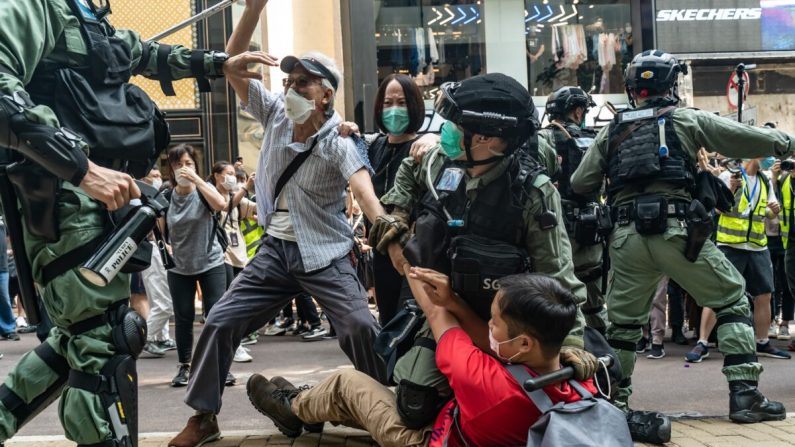 Los partidarios de la democracia luchan con la policía antidisturbios durante una detención en un mitin en el distrito de Causeway Bay en Hong Kong, el 27 de mayo de 2020. (Anthony Kwan/Getty Images)