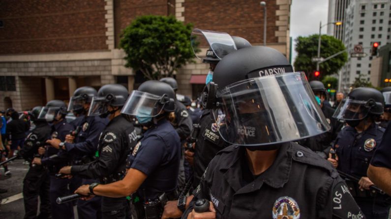 Oficiales de policía observan durante una protesta en respuesta a la muerte de George Floyd el 29 de mayo de 2020 en Los Ángeles, California. (Apu Gomes/Getty Images)