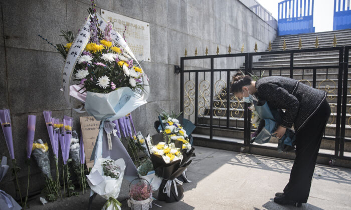 Un residente presenta flores a los mártires que murieron en la lucha contra el brote del virus del PCCh y a los compatriotas que murieron a causa de la enfermedad en Wuhan, China, el 4 de abril de 2020. (Getty Images)
