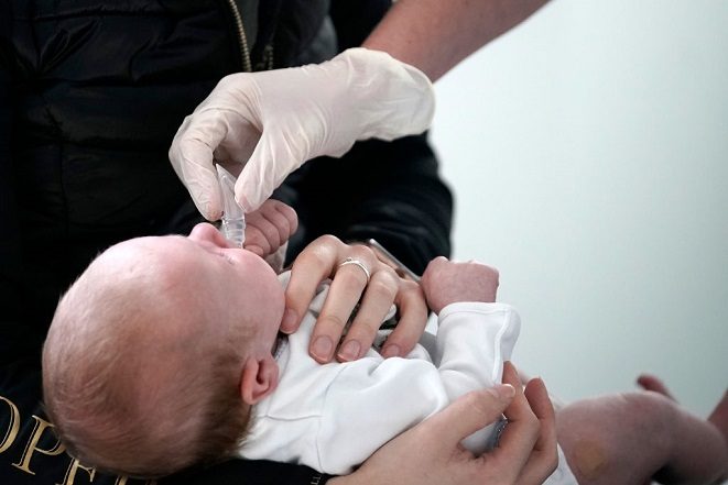 Una enfermera le da a un bebé una medicina después de administrarle las vacunas en el Centro Médico St Johns el 16 de abril de 2020 en Altrincham, Inglaterra. (Christopher Furlong/Getty Images)