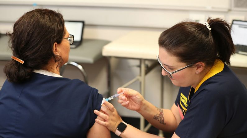 Una enfermera recibe una vacuna en un nuevo ensayo para probar si puede ayudar a reducir sus posibilidades de contraer COVID-19, en la clínica de pruebas del hospital Sir Charles Gairdner el 20 de abril de 2020 en Perth, Australia. (Paul Kane/Getty Images)