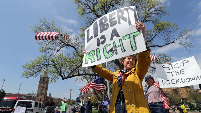  Los manifestantes sostienen carteles que animan a exigir que se permita la apertura de los negocios y que se permita a los ciudadanos volver a trabajar, en el Country Club Plaza el 20 de abril de 2020 en Kansas City, Missouri. (Jamie Squire/Getty Images)