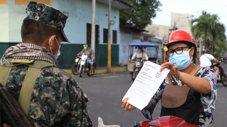 Una motociclista muestra su paso seguro a un oficial militar el 06 de mayo de 2020 en Iquitos, Perú. Iquitos, capital de la provincia más grande de Perú, está a punto de colapsar debido al creciente número de casos de COVID-19 en la región. (Getty Images/Getty Images)