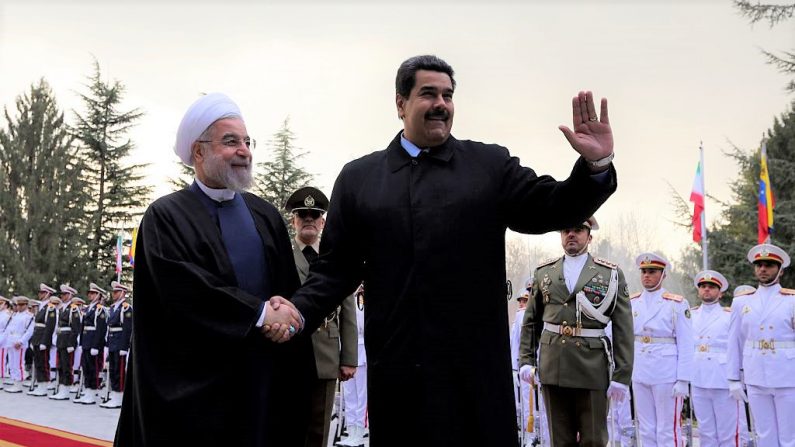 El líder iraní Hassan Rouhani (I) le da la mano al dictador venezolano Nicolás Maduro después de revisar la guardia de honor en el Palacio de Saadabad en Teherán el 10 de enero de 2015. (ATTA KENARE/AFP vía Getty Images)
