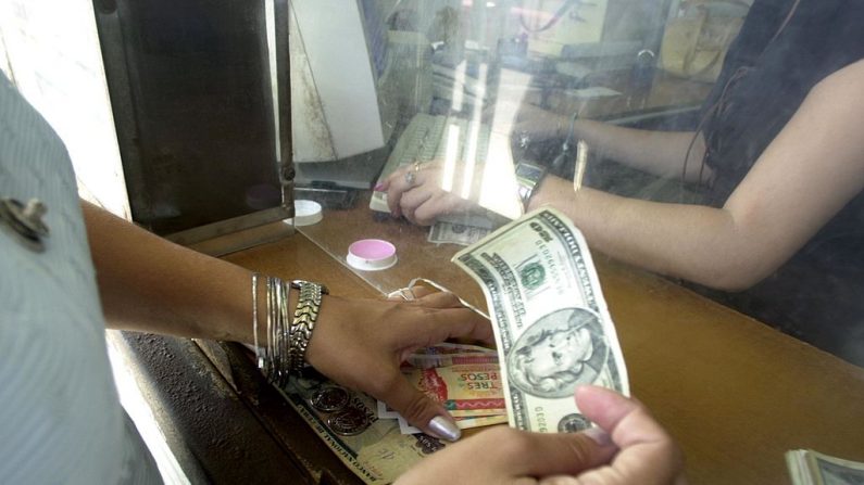 Una mujer intercambia dólares estadounidenses por pesos cubanos el 26 de octubre de 2004 en La Habana, Cuba. (Jorge Rey/Getty Images)