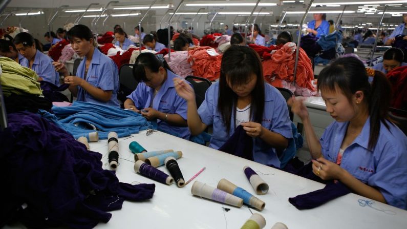Trabajadores cosen suéteres de cachemira en una fábrica de cachemira del Grupo Erdos el 15 de julio de 2007 en Erdos de la Región Autónoma de Mongolia Interior (China). (Foto de China Photos/Getty Images)