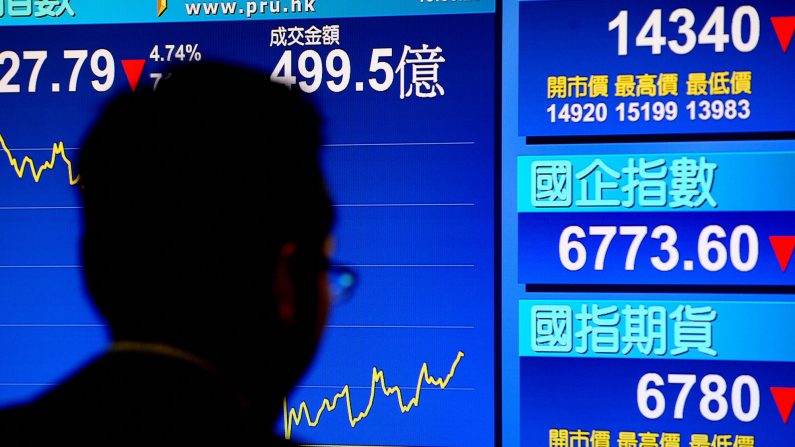 Un hombre aparece en una pantalla que muestra la caída del índice Hang Seng en una casa comercial en Hong Kong el 22 de octubre de 2008. (PHILIPPE LOPEZ/AFP a través de Getty Images)