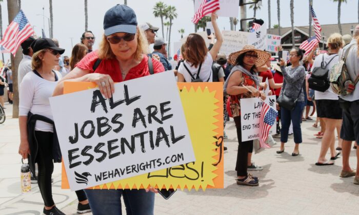 Una manifestante sostiene un cartel en Huntington Beach, California, el 9 de mayo de 2020. (Jamie Joseph / The Epoch Times)