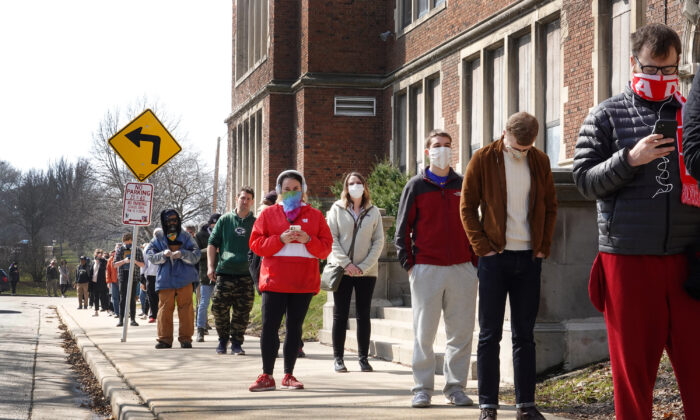 Los votantes esperan en fila para entrar en un colegio electoral de la Universidad de Riverside en Milwaukee, Wisconsin, el 7 de abril de 2020. (Scott Olson/Getty Images)