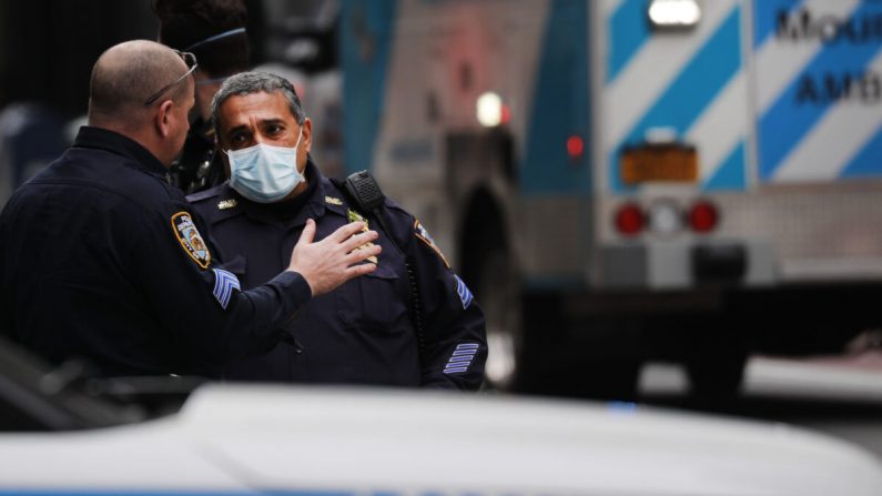 Los oficiales del Departamento de Policía de Nueva York usan mascarillas faciales mientras asisten en un accidente en la ciudad de Nueva York el 20 de abril de 2020. (Spencer Platt/Getty Images)