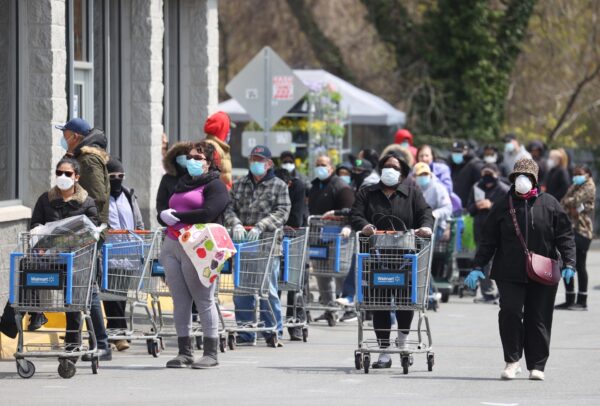 Las personas que usan mascarillas y guantes esperan para entrar a un Walmart en Uniondale, Nueva York, el 17 de abril de 2020. (Al Bello/Getty Images)