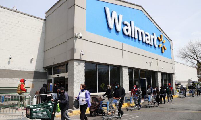 Las personas con mascarillas y guantes esperan para entrar en un Walmart en Uniondale, N.Y., el 17 de abril de 2020. (Al Bello/Getty Images)
