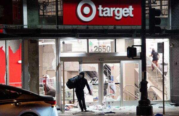 Un saqueador roba una tienda de Target mientras los manifestantes se enfrentan a la policía por la muerte de George Floyd, en Oakland, California, el 30 de mayo de 2020. (Josh Edelson/AFP/Getty Images)