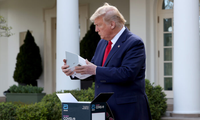 El presidente Donald Trump sostiene un kit de prueba rápida de COVID-19 desarrollado por Abbott Labs en el Jardín de Rosas de la Casa Blanca en Washington el 30 de marzo de 2020. (Win McNamee/Getty Images)