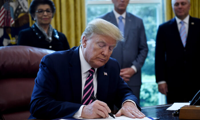 El presidente Donald Trump firma el Programa de Protección de Cheques y la Ley de Mejora de la Atención Médica en la Oficina Oval de la Casa Blanca en Washington, el 24 de abril de 2020. (Olivier Douliery/AFP vía Getty Images)
