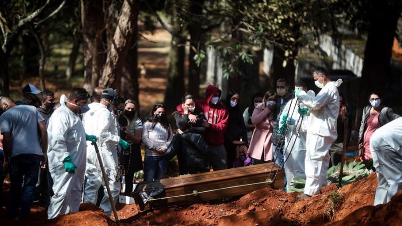 Sepultadores entierran una victima sospechosa de la covid-19, este lunes, en el cementerio de Vila Formosa en Sao Paulo (Brasil). EFE/ Fernando Bizerra
