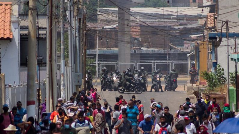 Fotografía fechada el 25 de mayo de 2020 donde se observa a un grupo de militares bloquear el paso a comerciantes en los accesos del mercado "Las Pulgas", en Maracaibo (Venezuela). EFE/ Henry Chirinos
