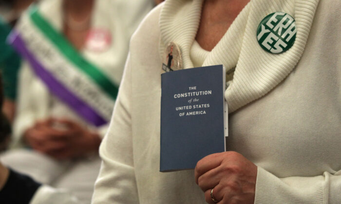 Una activista sostiene una copia de la Constitución de los Estados Unidos durante una conferencia de prensa sobre los derechos de las mujeres en el Capitolio en Washington, el 30 de abril de 2019. (Alex Wong/Getty Images)