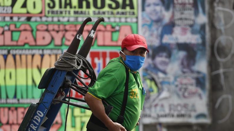 Un hombre con tapabocas trabaja en el Mercado Mayorista de Frutas de Lima (Perú). EFE/Paolo Aguilar/Archivo
