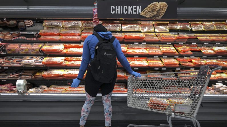 Una mujer compra en la sección de pollo y carne en una tienda de comestibles en Washington el 28 de abril de 2020. (Drew Angerer/Getty Images)
