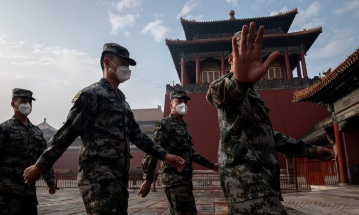 Soldados del Ejército Popular de Liberación de China marchan junto a la entrada de la Ciudad Prohibida durante la ceremonia de apertura de una reunión política en Beijing el 21 de mayo de 2020. (NICOLAS ASFOURI / AFP a través de Getty Images)