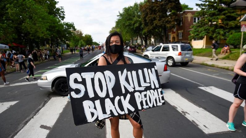La estadounidense Amy Gee participa en una protesta celebrada el 26 de mayo en Mineápolis, EE.UU, en el lugar donde falleció el afroamericano George Floyd a manos de policías un día antes. EFE/ Craig Lassig

