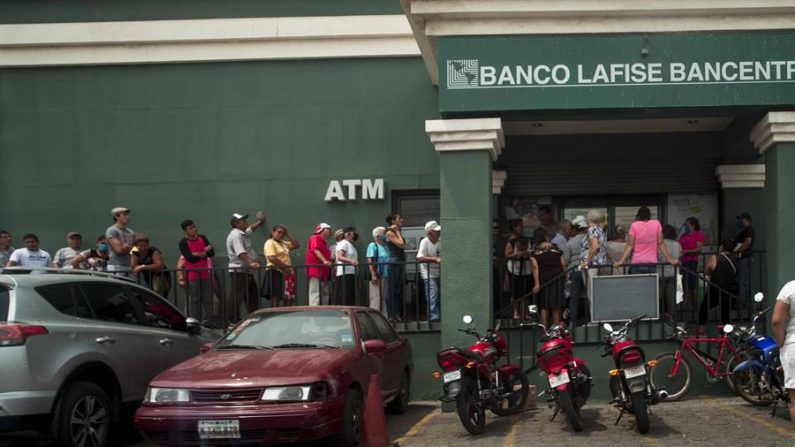 Varios adultos mayores hacen fila para retirar su pensión de jubilación en un banco el 5 de mayo de 2020, en Managua (Nicaragua). EFE/ Jorge Torres